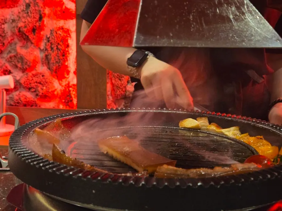 Staff grilling meat and mushrooms