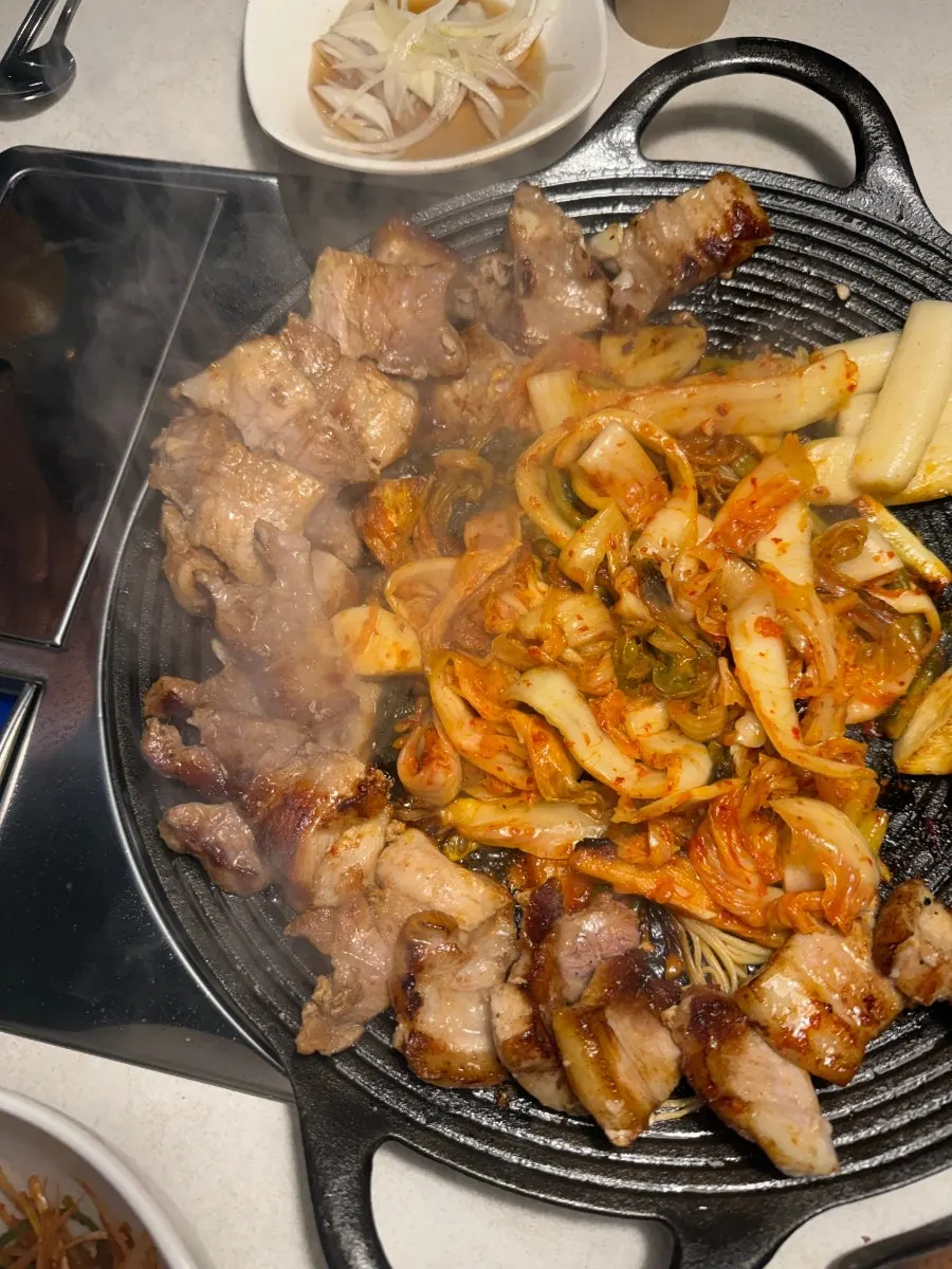 맛김치삼겹살과 사이드 메뉴가 차려진 테이블