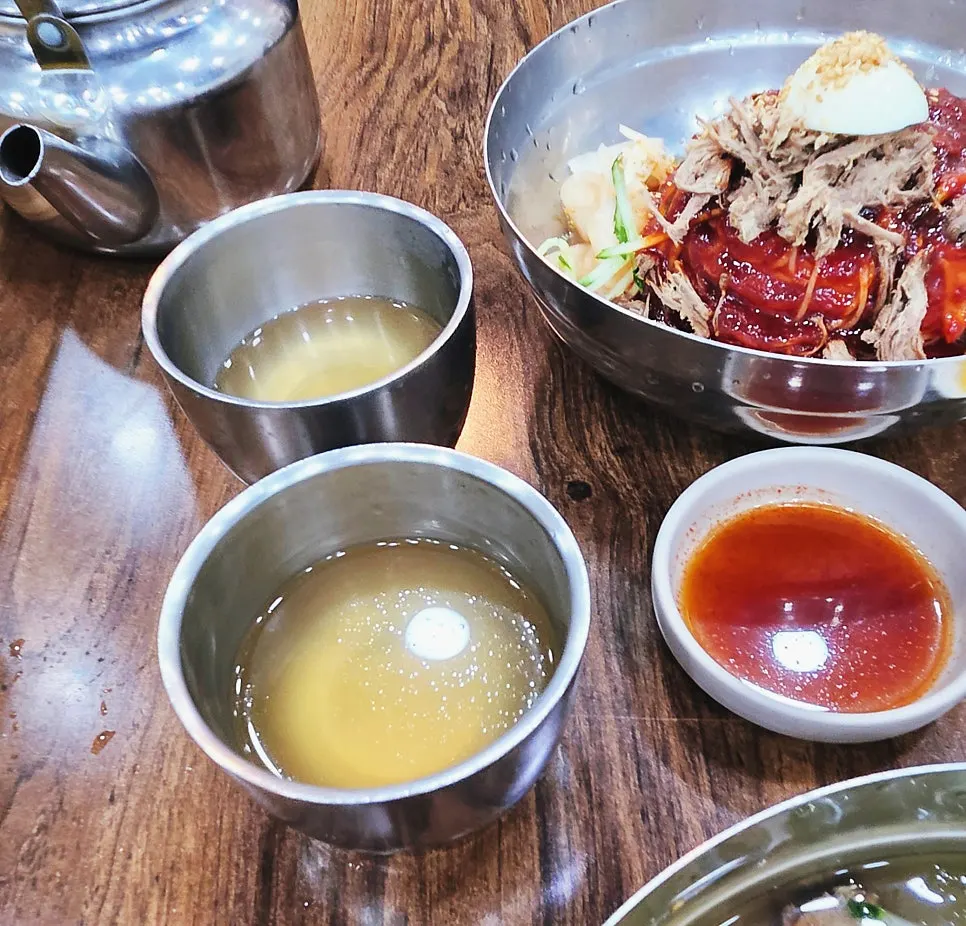 Warm broth served alongside the milmyeon