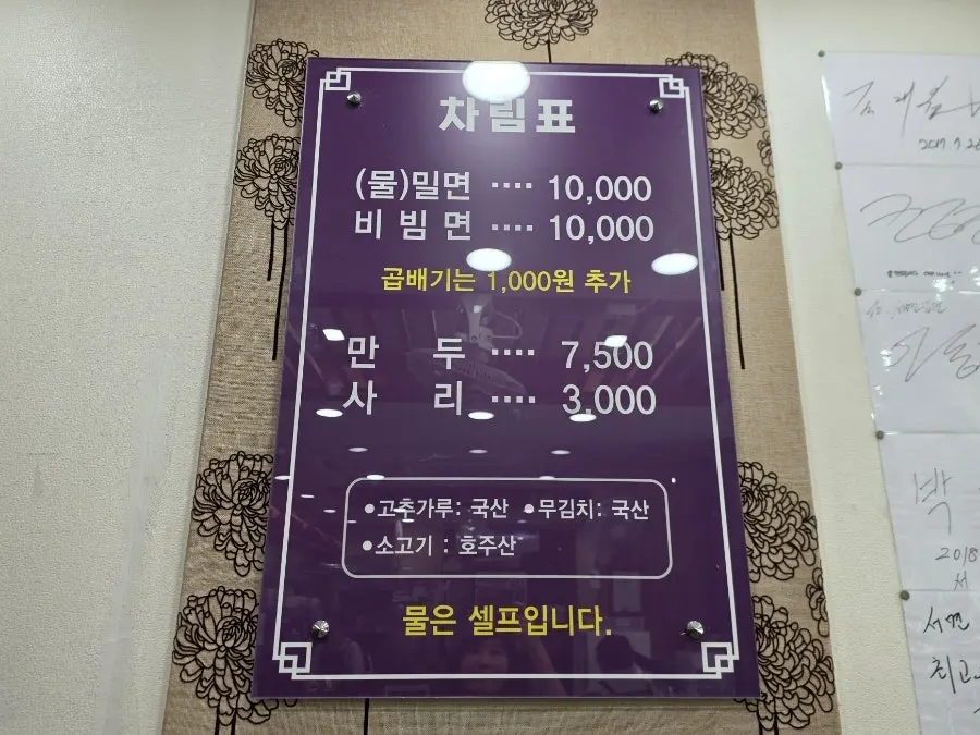 Seomyeon Milmyeon menu board listing mul-milmyeon, bibim-milmyeon, dumplings, and extra noodles