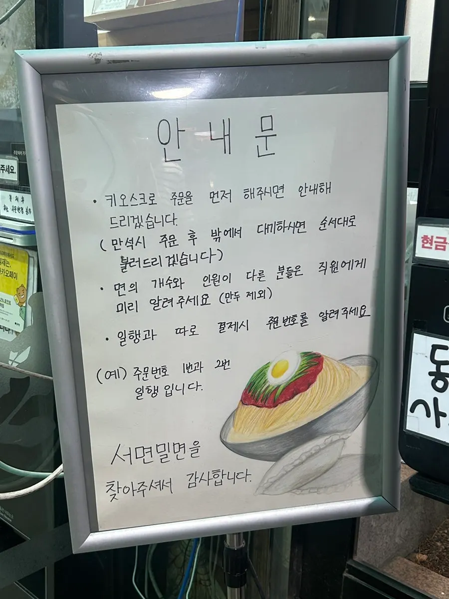 Entrance sign at Seomyeon Milmyeon with a milmyeon illustration