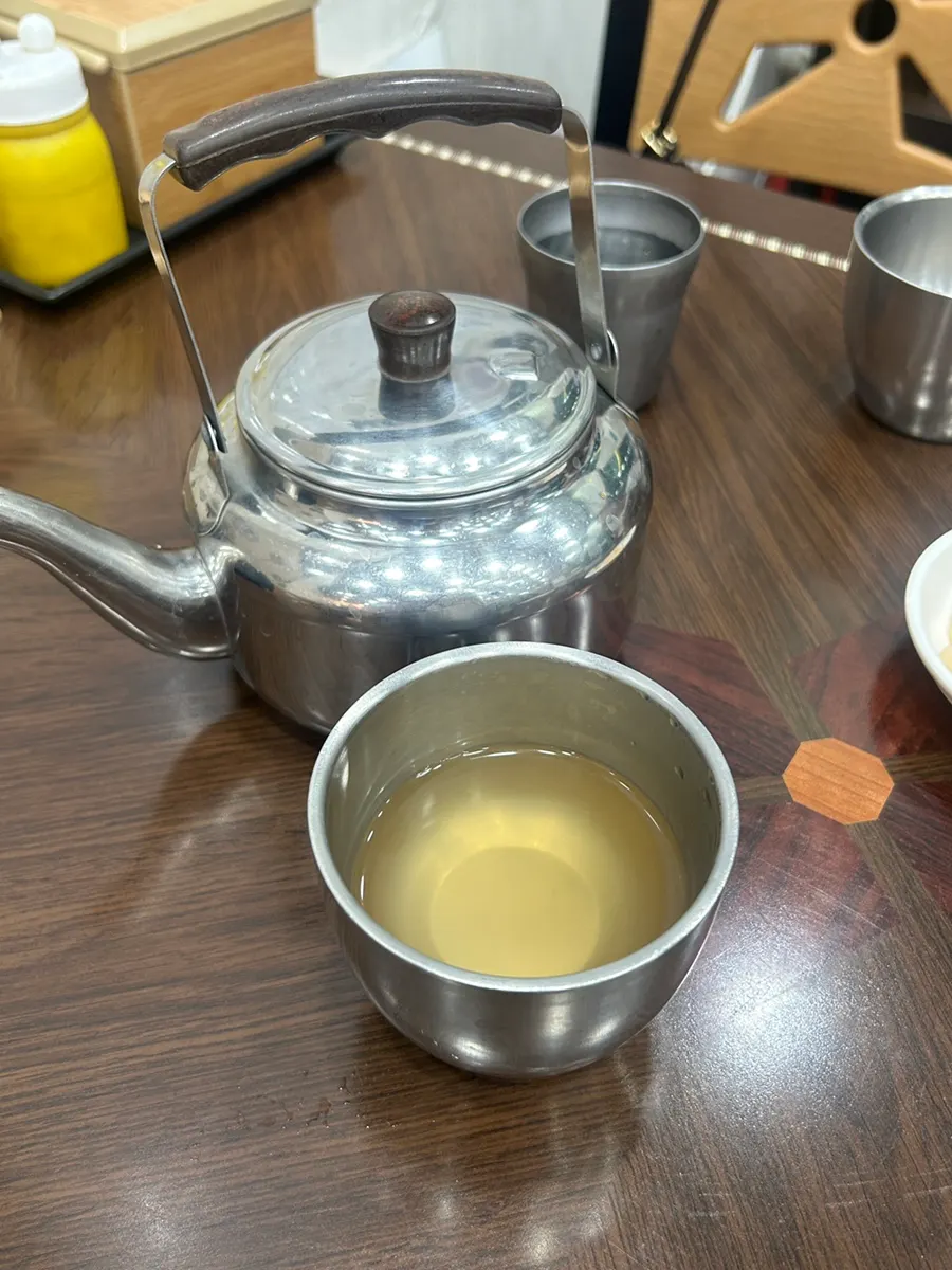 Warm broth served in a kettle at Seomyeon Milmyeon