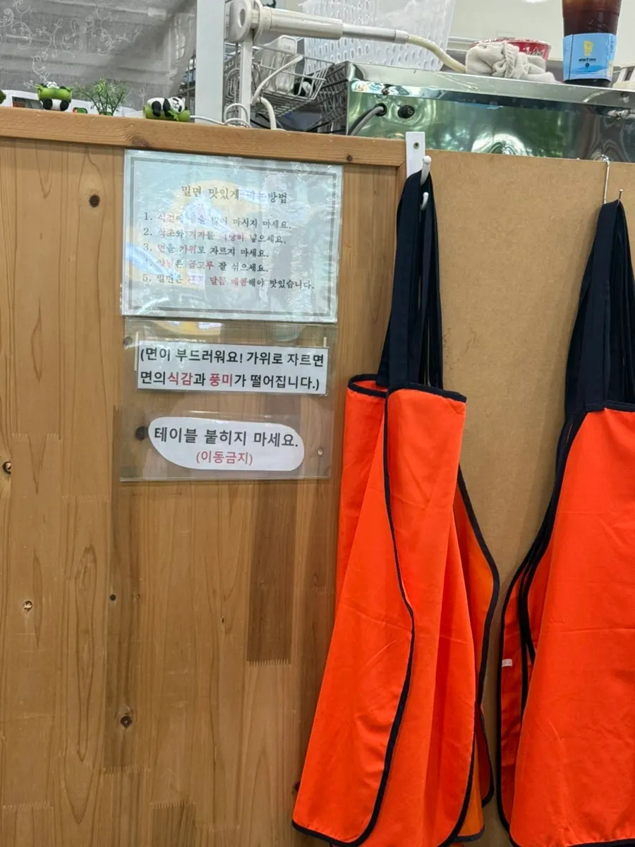 Menu and signage on a table at Seomyeon Milmyeon
