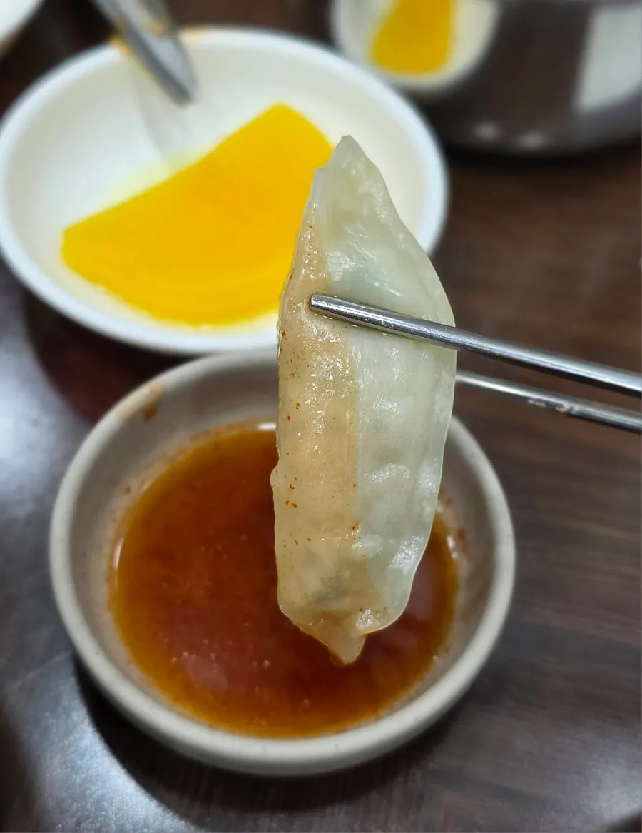 Một miếng mandu chấm xì dầu