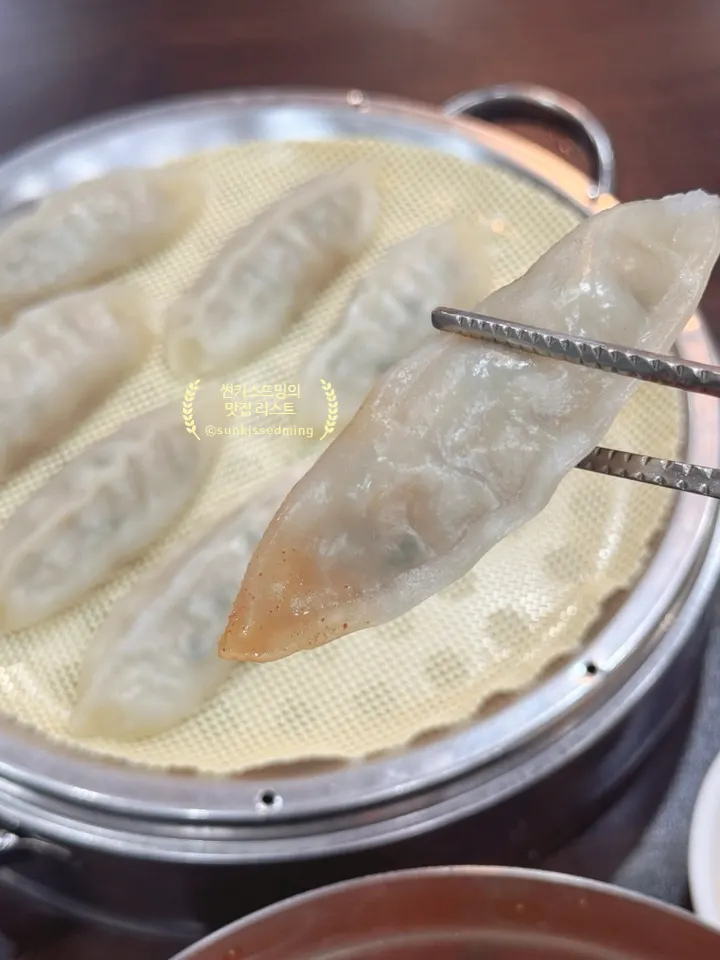 A dumpling being dipped in soy sauce