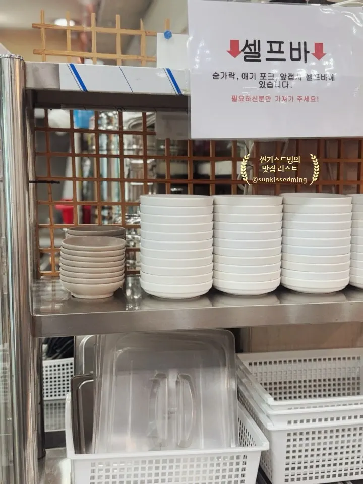Self-serve bar with side plates and utensils at Seomyeon Milmyeon