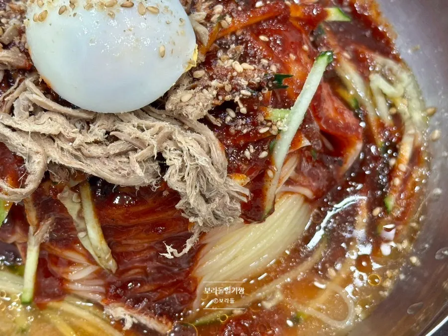 장조림처럼 찢은 고기 고명이 올라간 비빔밀면