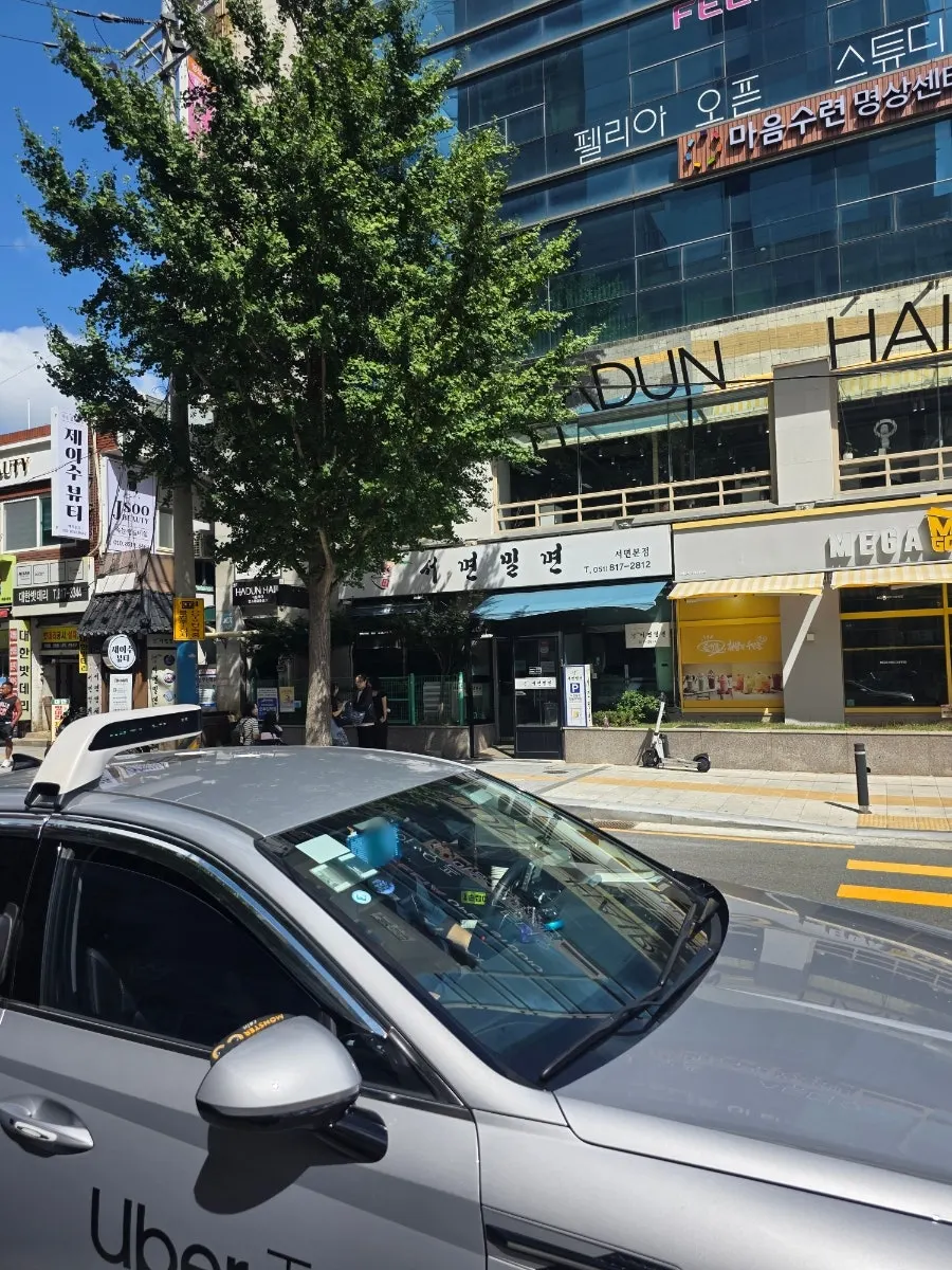 Puerta de entrada con el cartel de horario de Seomyeon Milmyeon