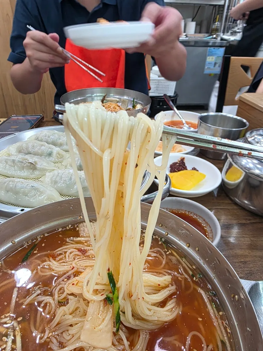 Carne de res cocida y kimchi de rábano sobre el milmyeon de agua