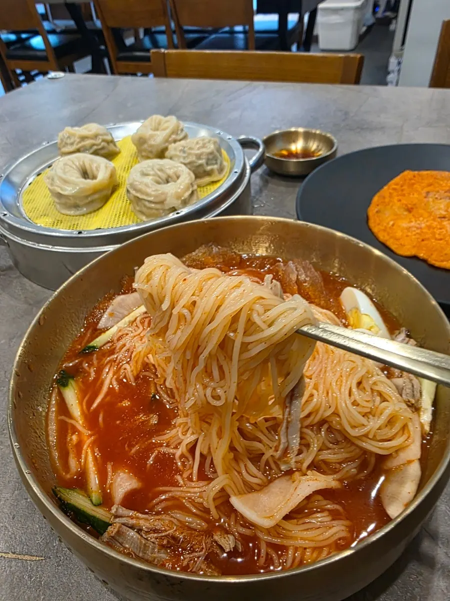 젓가락으로 들어 올린 쫄깃한 밀면 면발