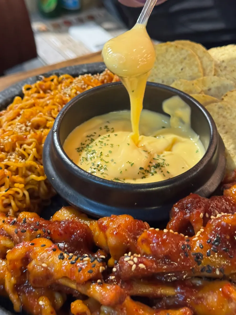 Nacho cheese stretching over the chicken feet