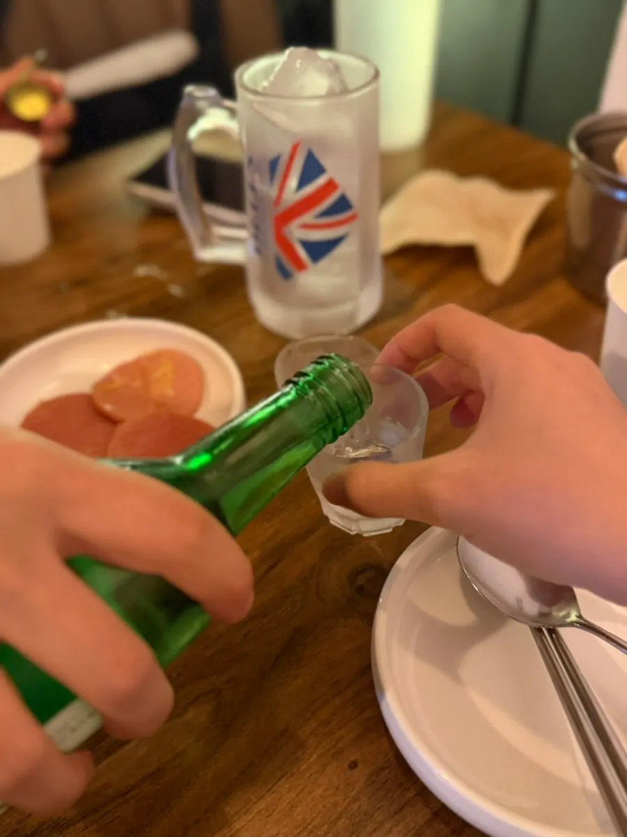 A glass of soju poured