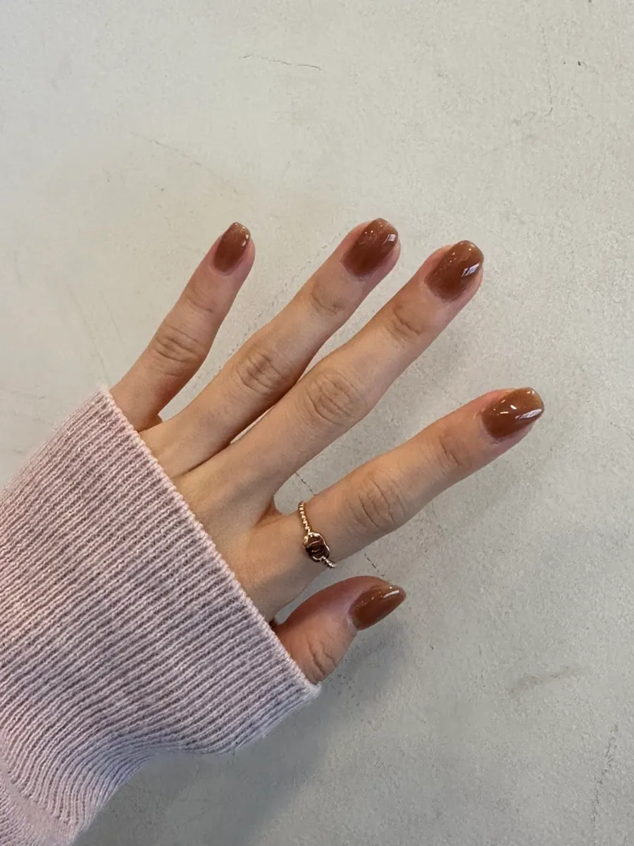 Low-saturation brown nails matched to the hand's line