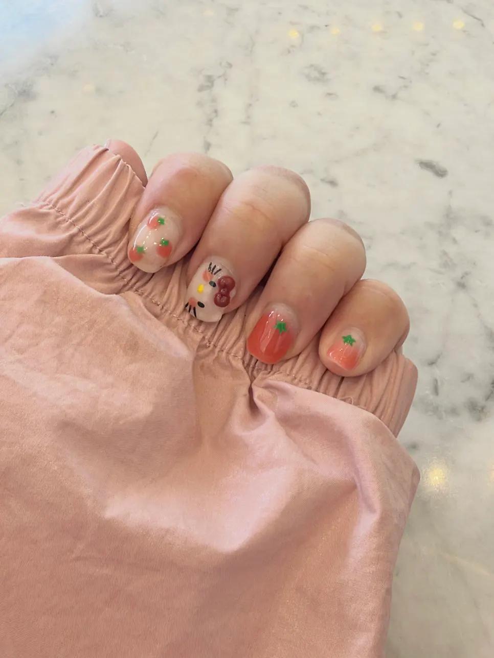 Both hands showing the finished Hello Kitty nails