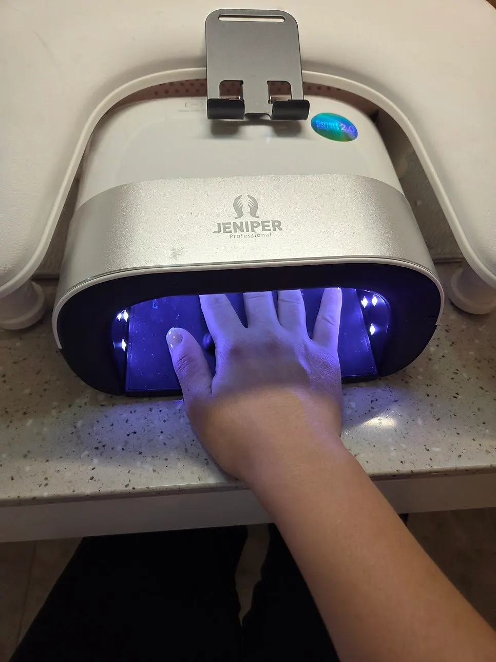 Curing the gel under a lamp during the manicure