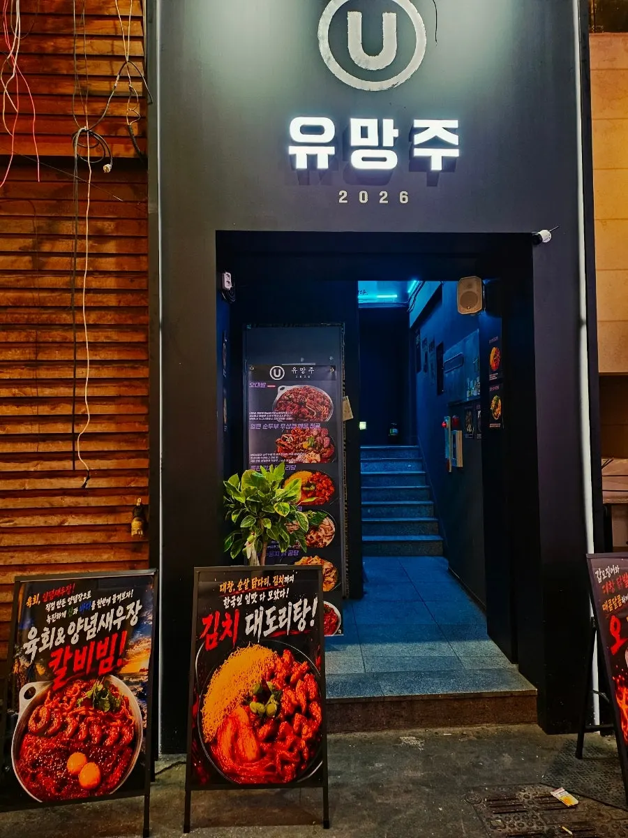 Standing sign with photos of food outside Yuumangju Seomyeon Branch