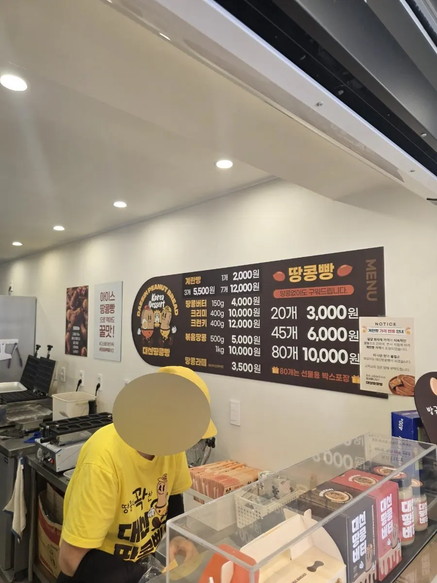 Owner in yellow uniform packing bread