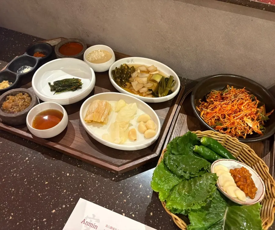 Korean BBQ table setting and side dishes at Anmin Busan