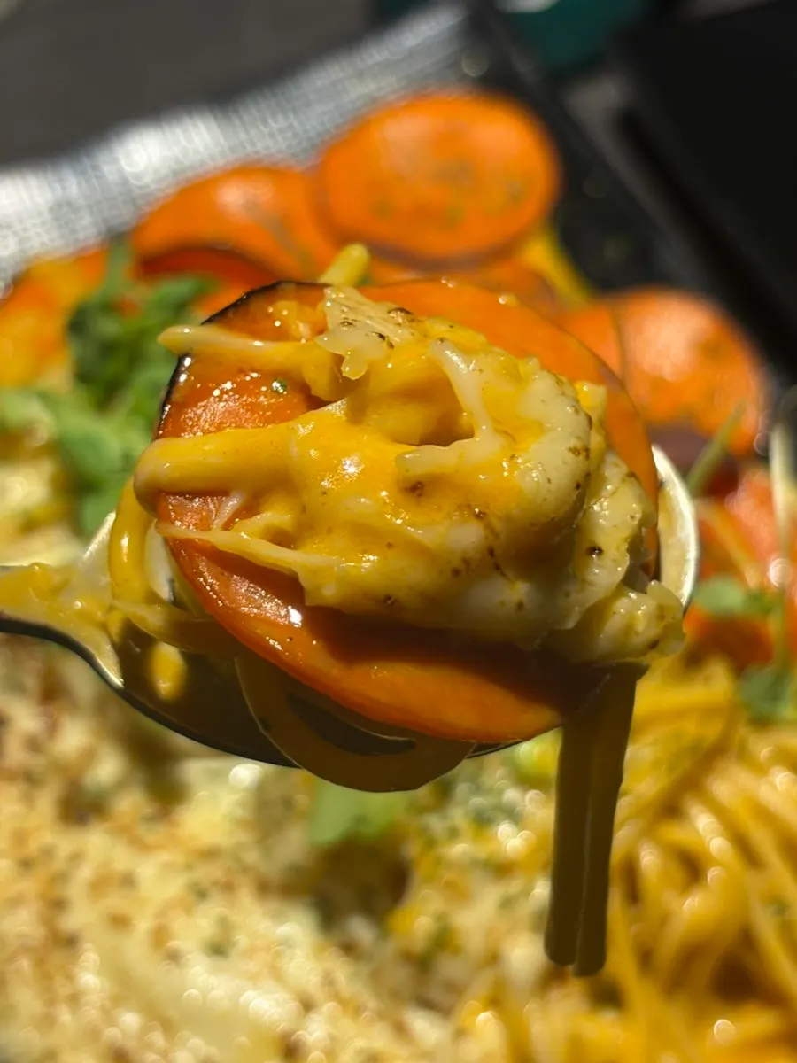 A forkful of cream pasta twirled with cheese