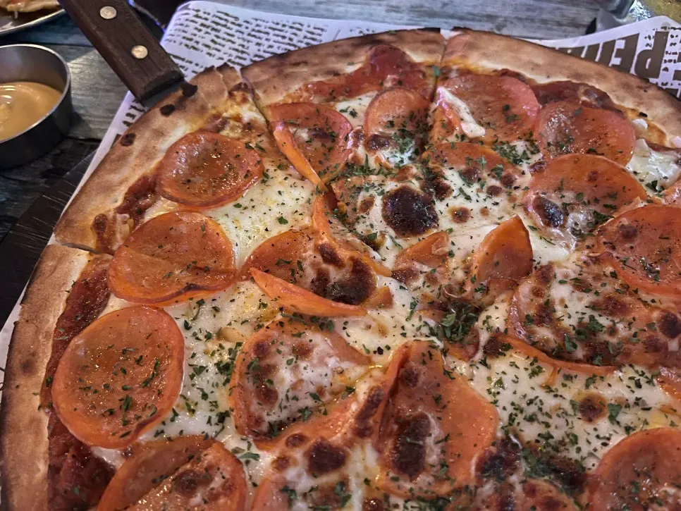 A slice cut from the pepperoni pizza