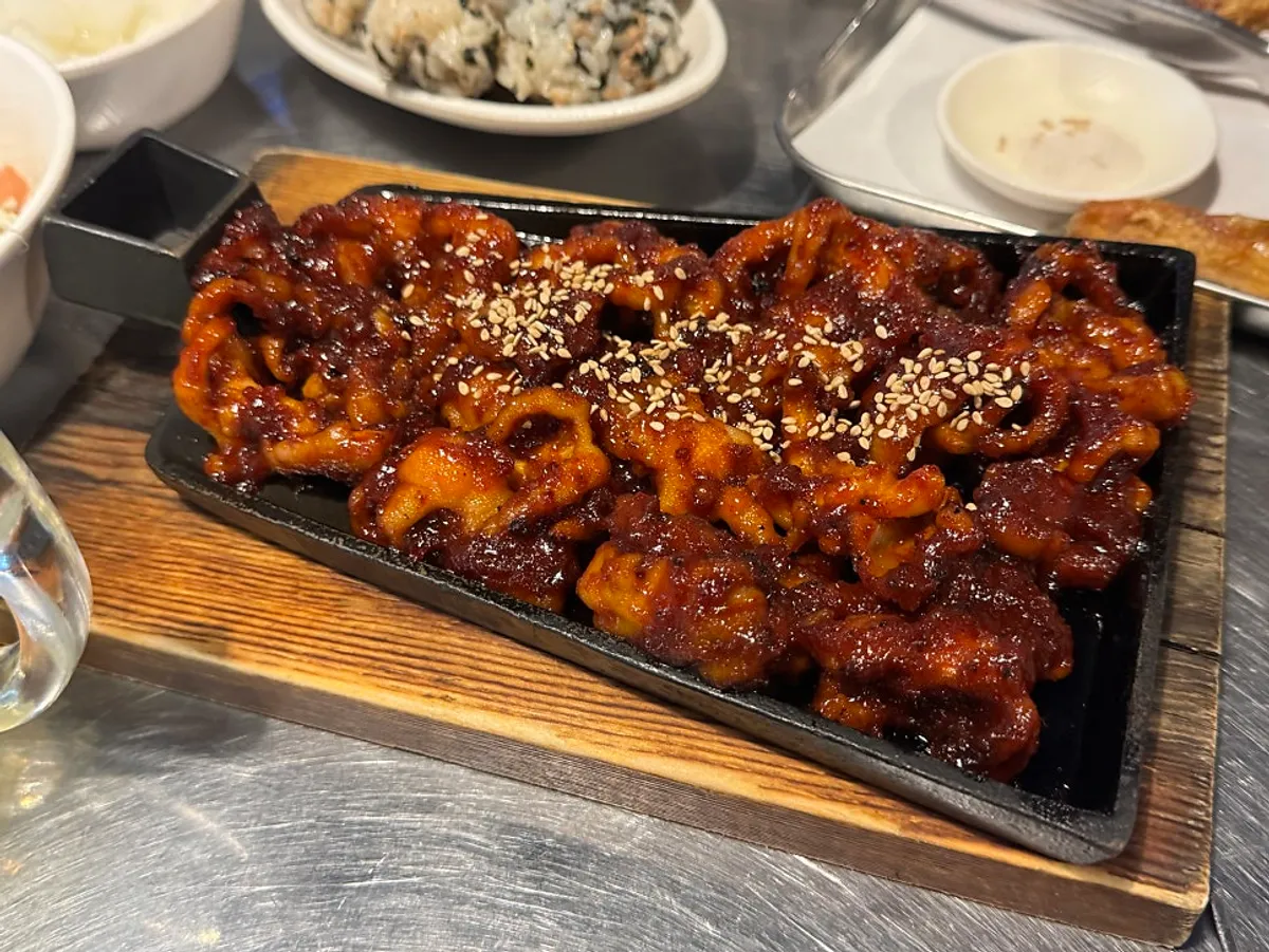 Charcoal-grilled boneless dakbal served on an iron plate