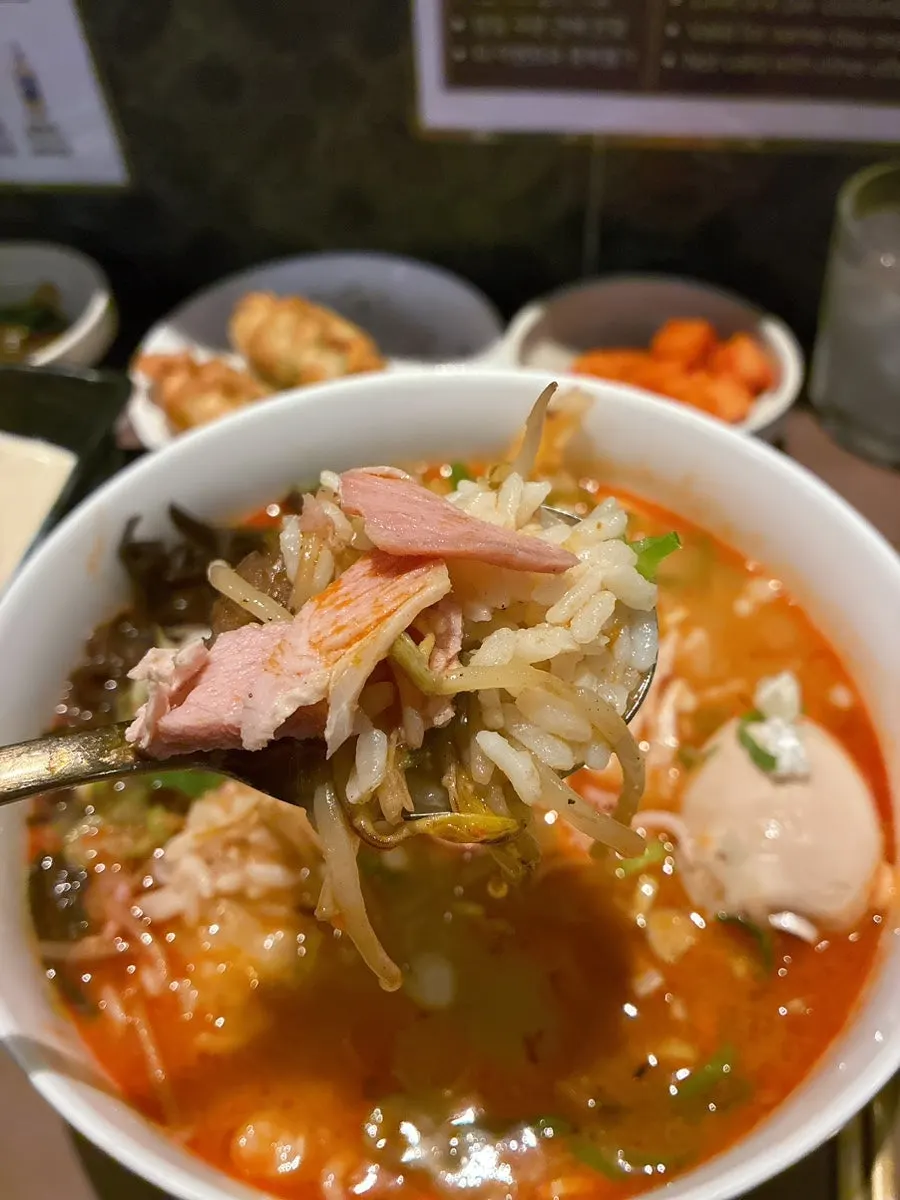 A bowl of spicy pork gukbap topped with ingredients