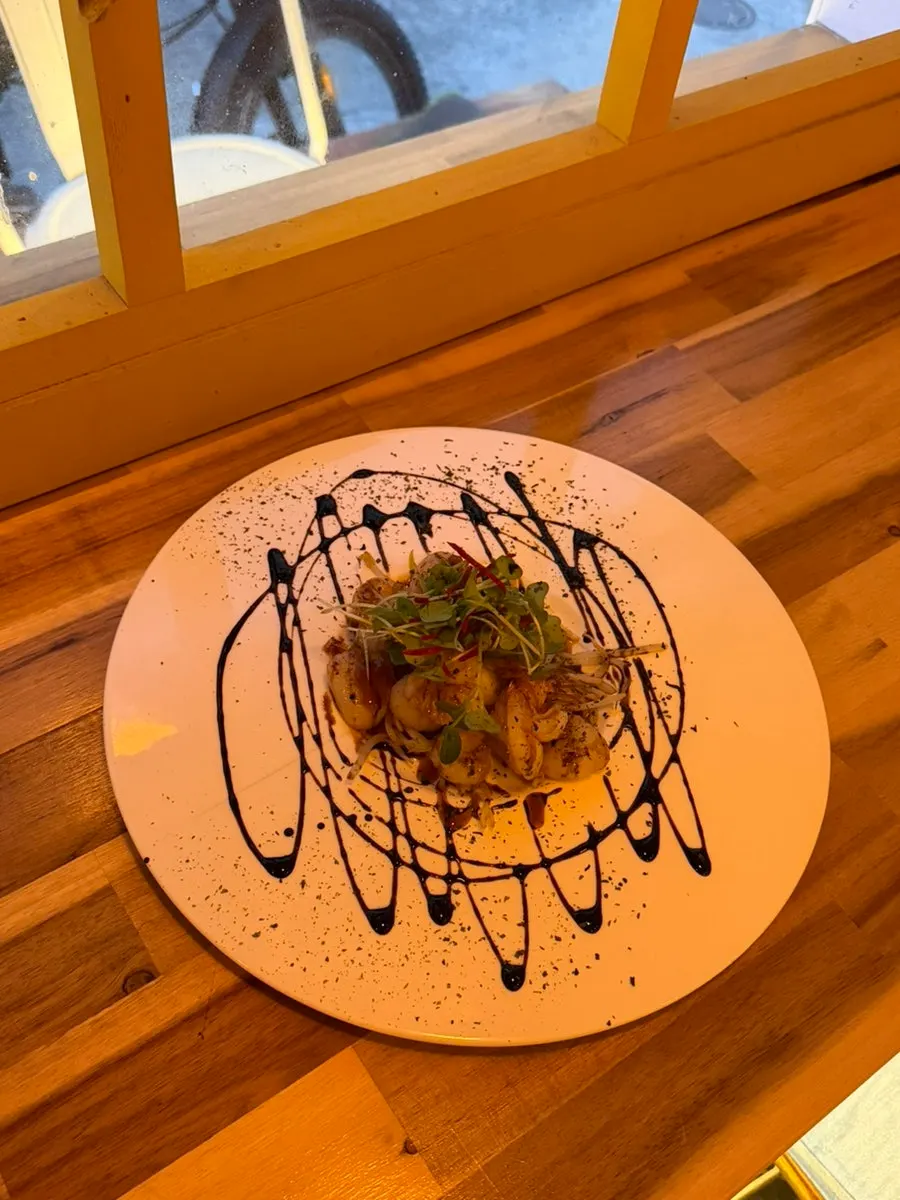 Vieiras y camarones cocinándose en la plancha con mantequilla