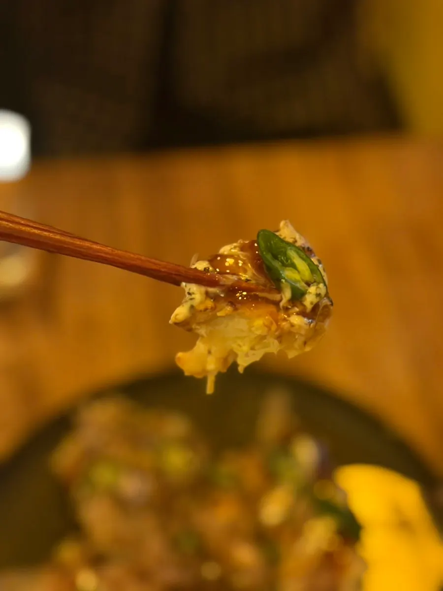 Shrimp okonomiyaki cocinándose en la plancha