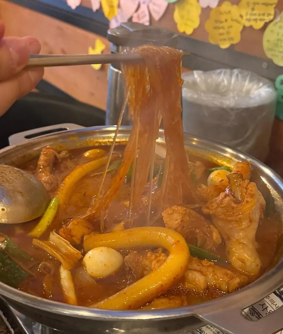 A piece of chicken lifted out of the dakdoritang