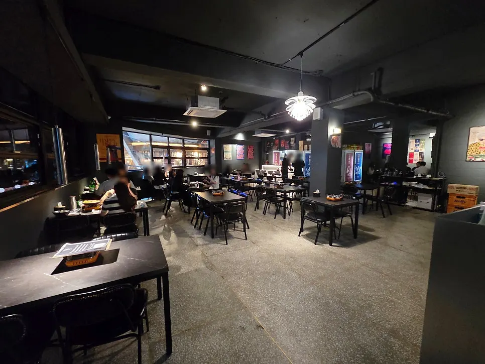 Black-toned, dimly lit tables inside Yuumangju Seomyeon Branch