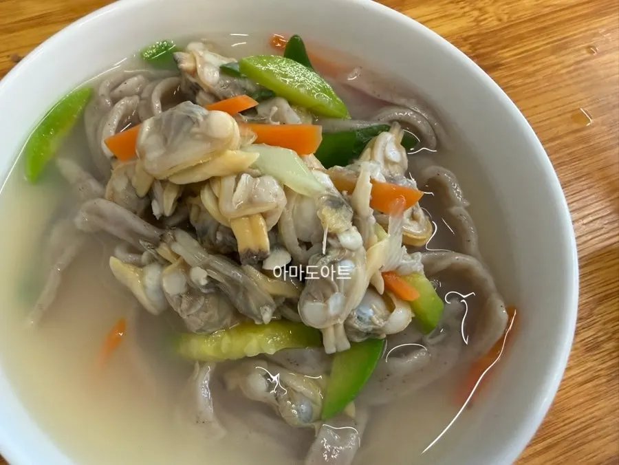 껍데기를 까놓은 바지락 살과 칼국수