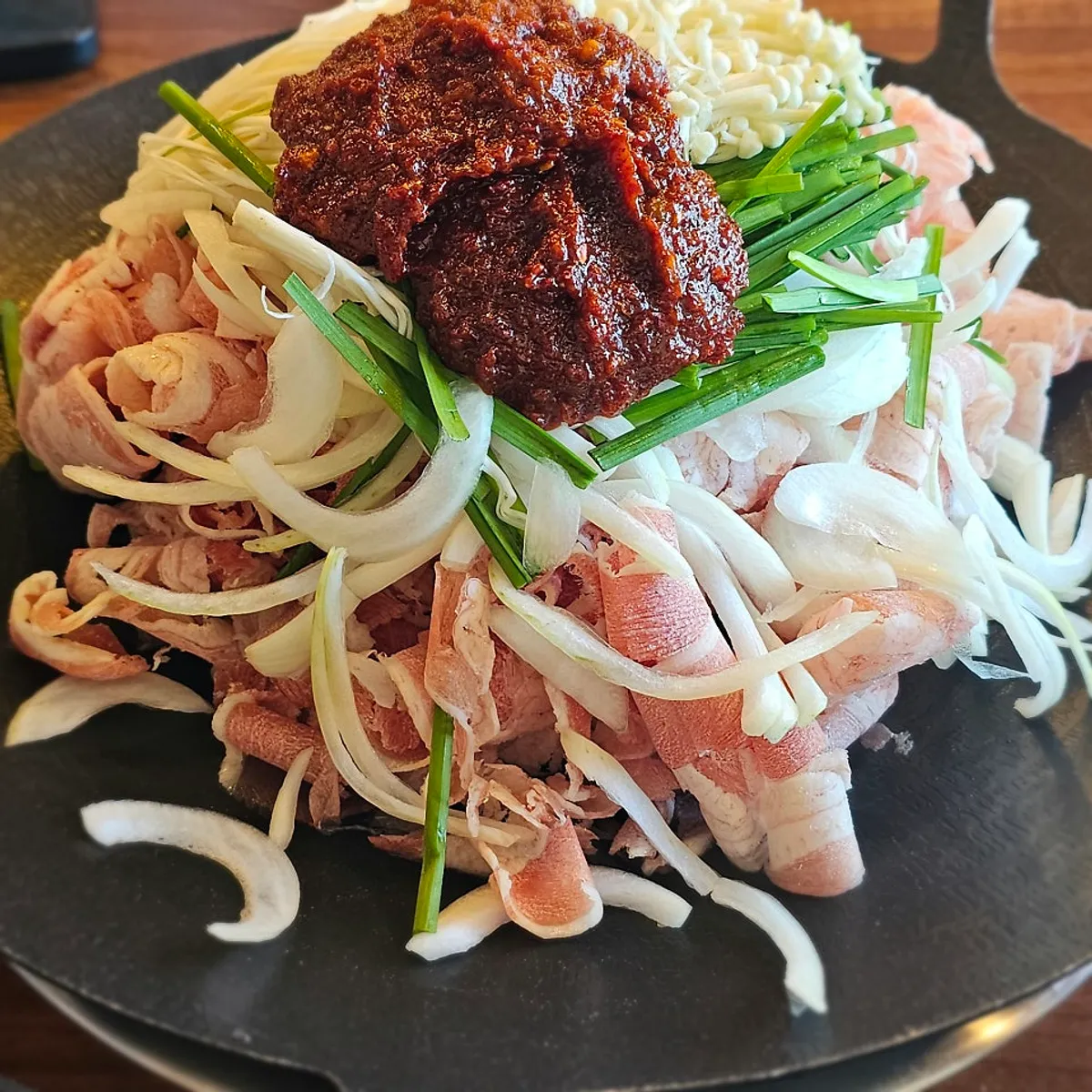 Duck bulgogi piled high like a mountain on the stone plate