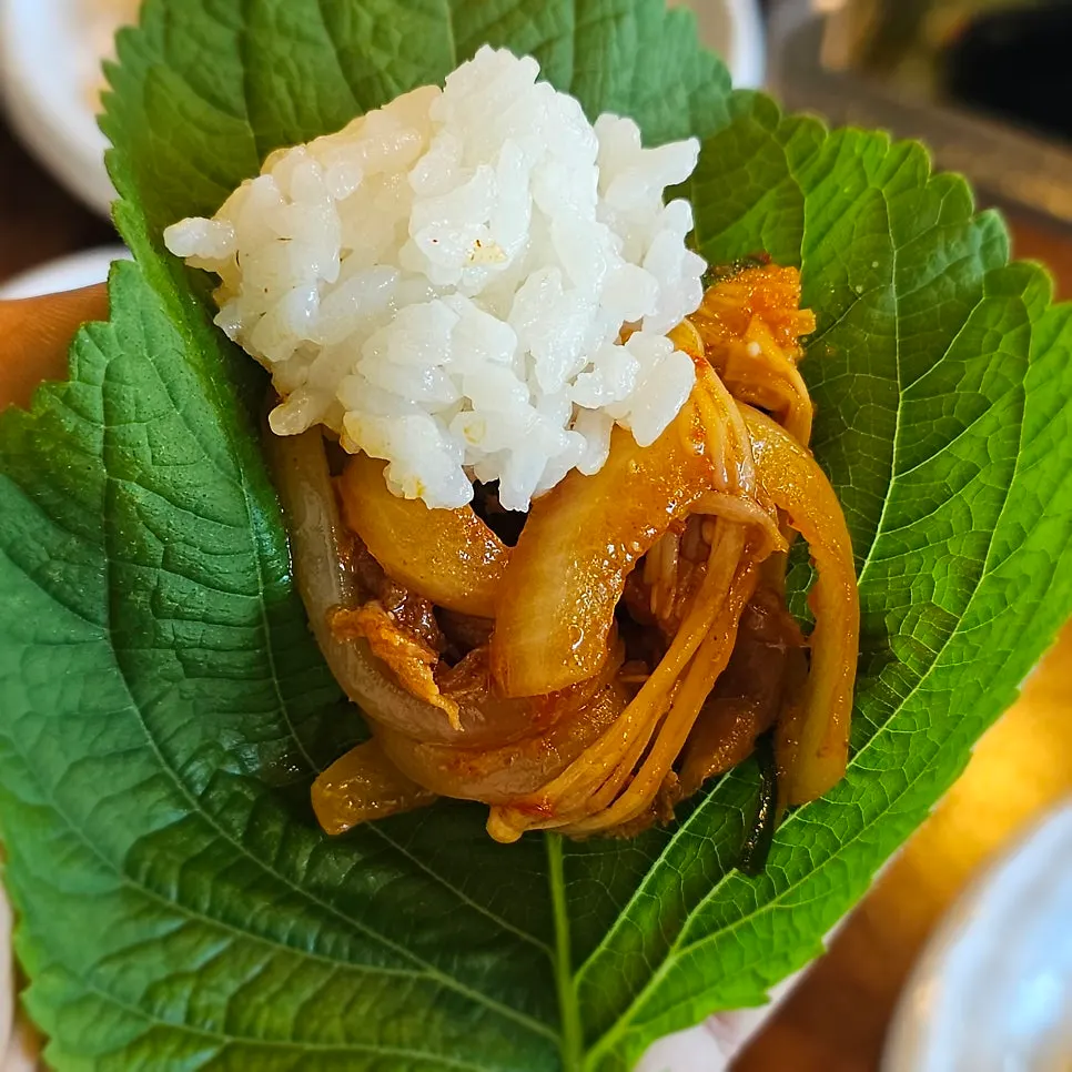 A single bite of duck bulgogi wrapped in lettuce