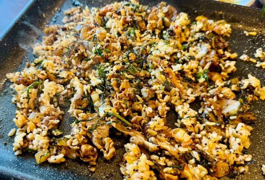 Finishing fried rice cooked on the grill pan