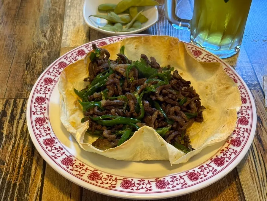 The ordered stir-fried beef with peppers and draft beer