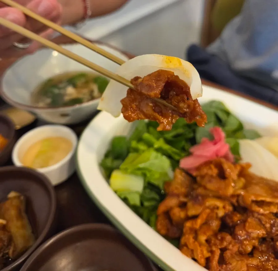 삼겹살 덮밥을 한 술 떠 올린 모습