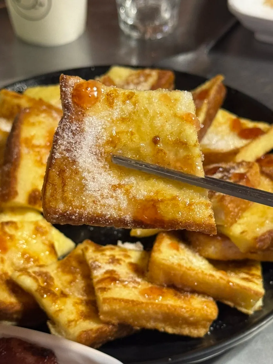 French toast topped with maple syrup and strawberry jam