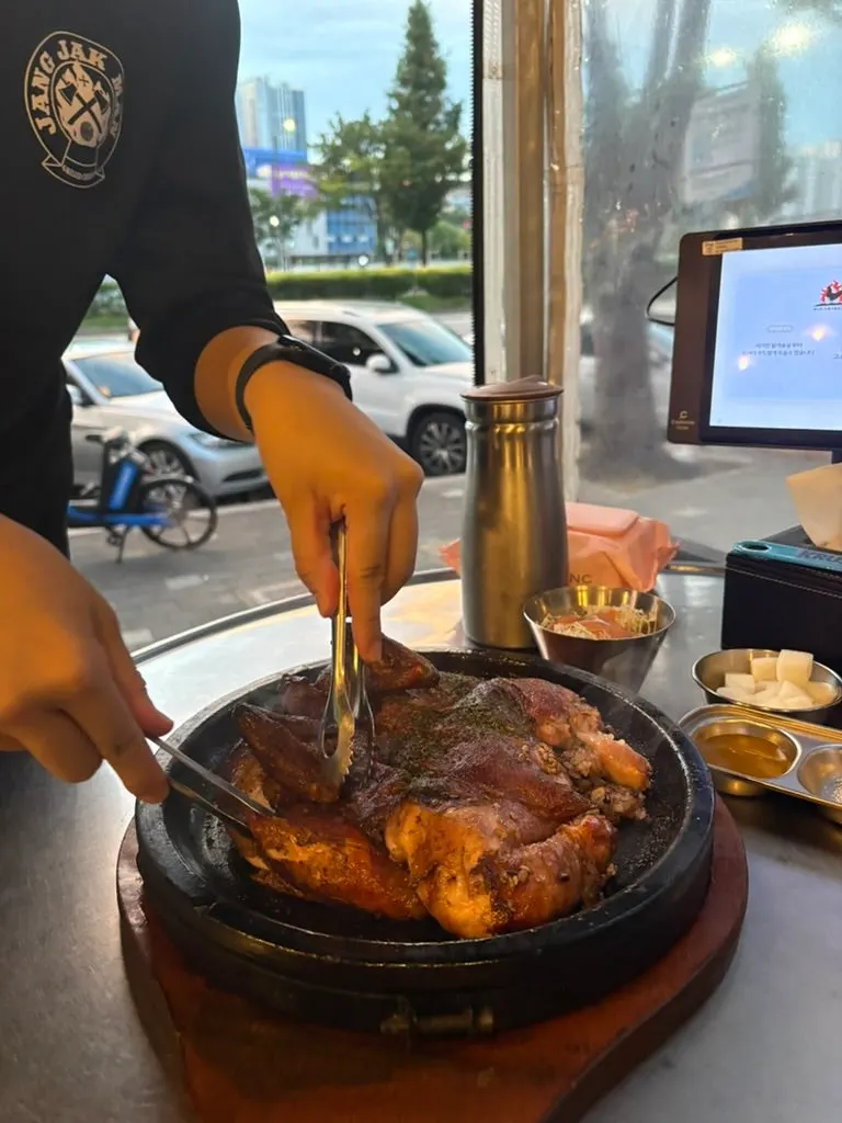 A whole herbal scorched-rice chicken on a hot stone plate