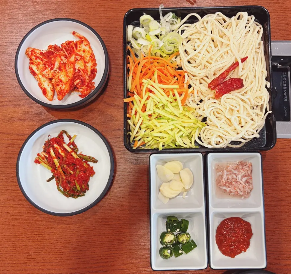 Kalguksu topped with zucchini, carrot, green onion, and whole red chili