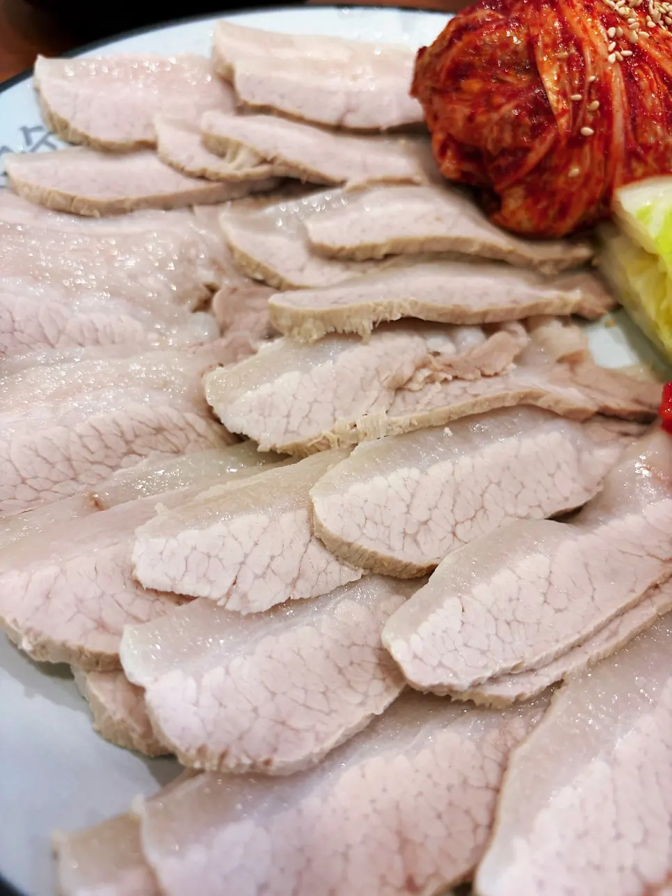 A plate of bossam served with seasoned dried radish strips