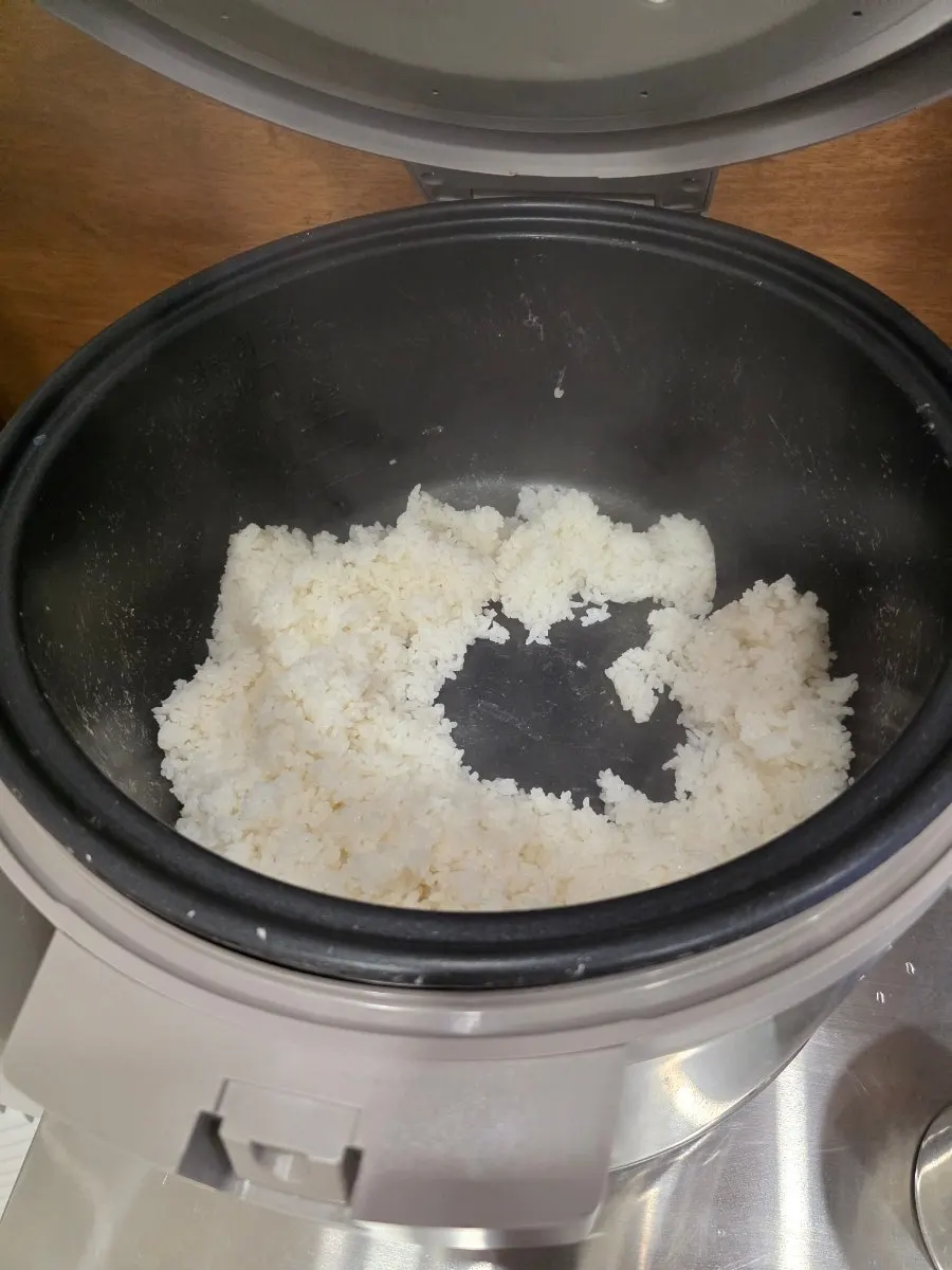Self-serve corner with side dishes, rice, and water