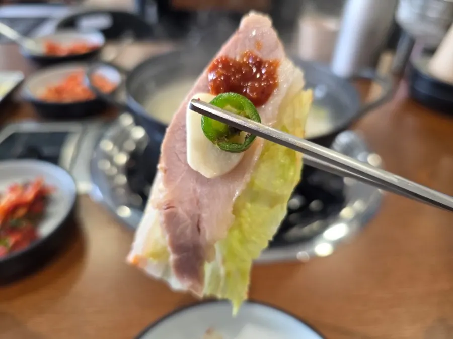 새우젓을 올린 가브리살 보쌈 한 점