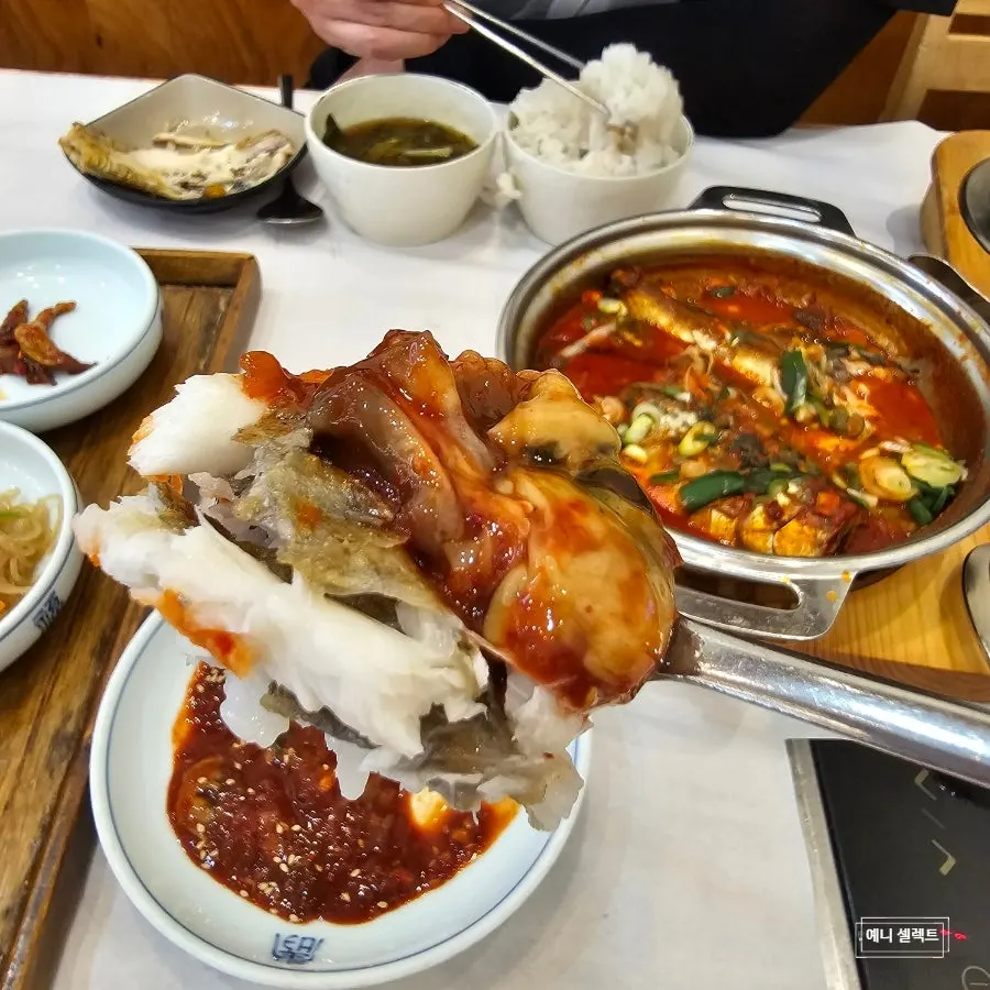 A bite of grilled fish topped with salted fermented oysters