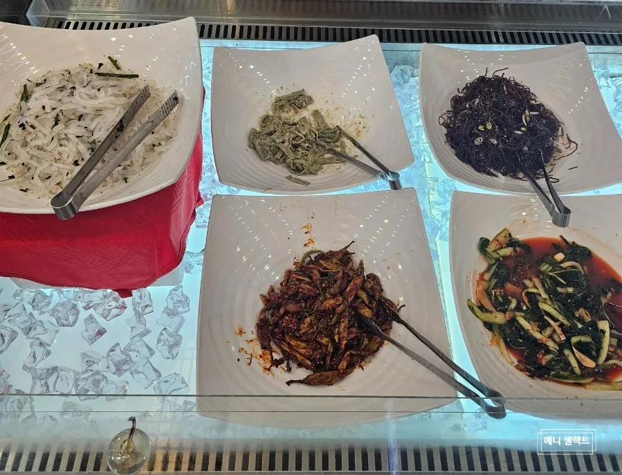 Banchan self-bar with seasoned greens and japchae