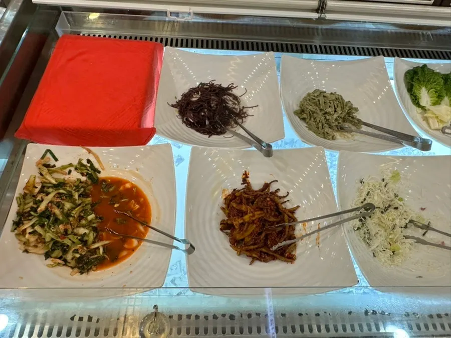 Dining table with grilled fish, sotbap, and side dishes