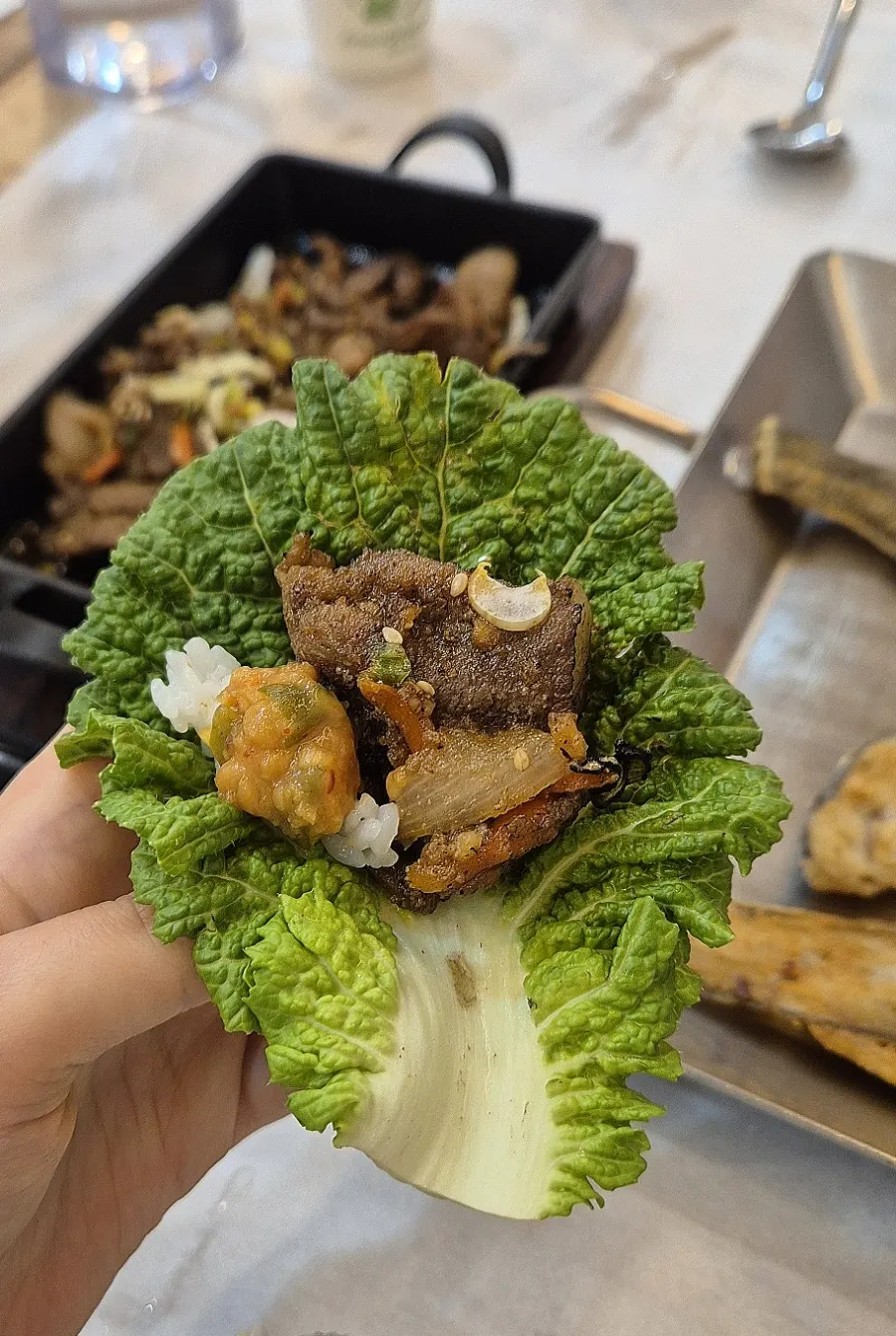 Wrapping grilled bulgogi in a lettuce ssam