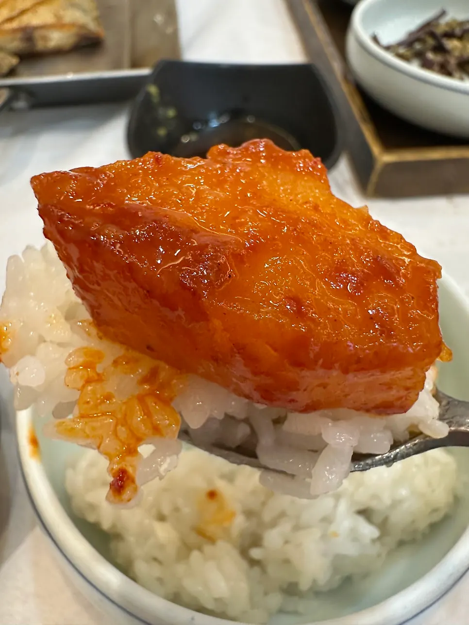 A thick chunk of braised silver cutlassfish lifted with chopsticks