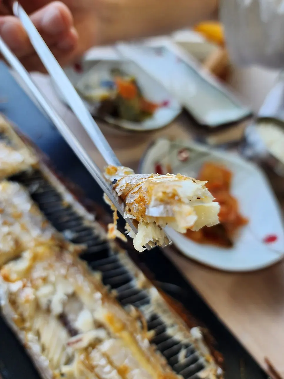 Table with the grilled cutlassfish and side dishes