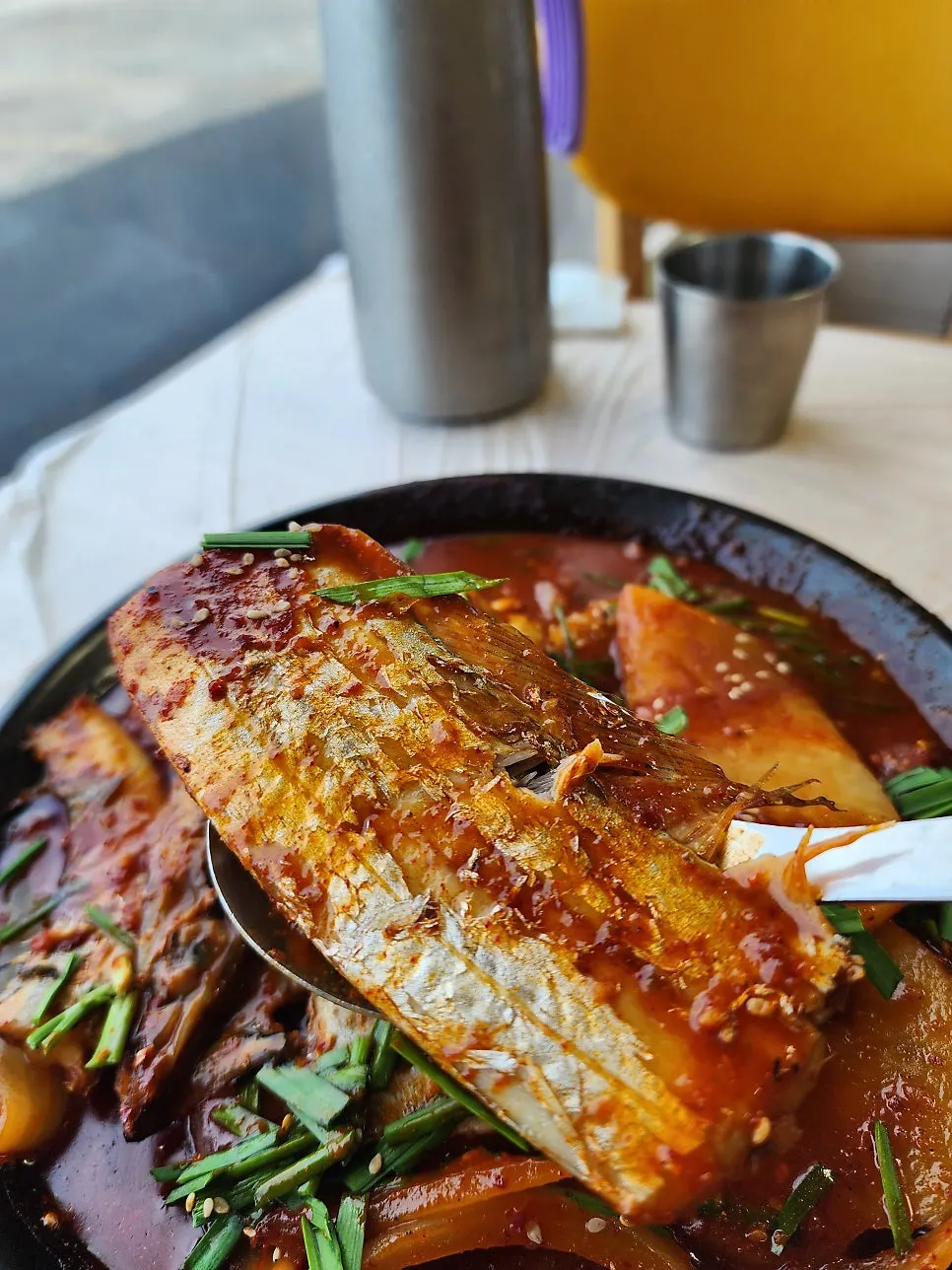 A spoonful of braised cutlassfish over rice