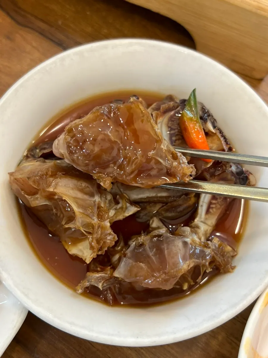 A plump crab pulled out of the stew